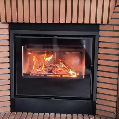 Insert à bois intégré dans une cheminée (habillage en bois)