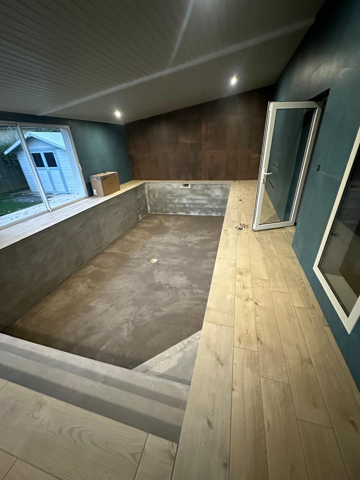 Pose de carrelage autour d'une piscine intérieure
